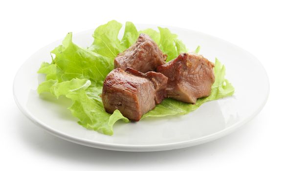 Three pieces of roasted meat with fresh lettuce on the white plate