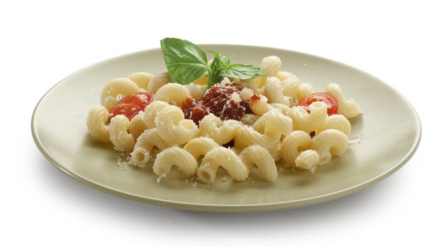 Pasta with tomato sauce, tomatoes, cheese and fresh green basil on the plate