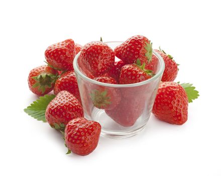 Handful of fresh strawberries with green leaves and glass