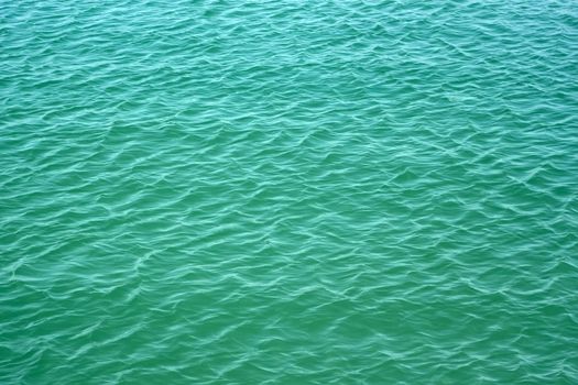 Easy waves on surface of turquoise color sea water in a calm summer weather