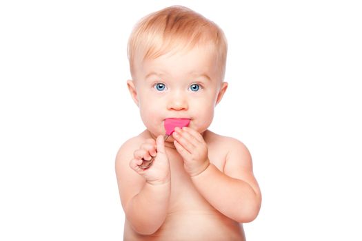 Cute adorable infant baby with food spoon in mouth eating and blue eyes, isolated.