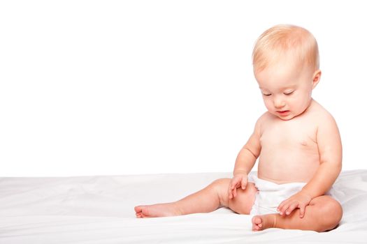 Cute adorable infant baby sitting alone, on white.