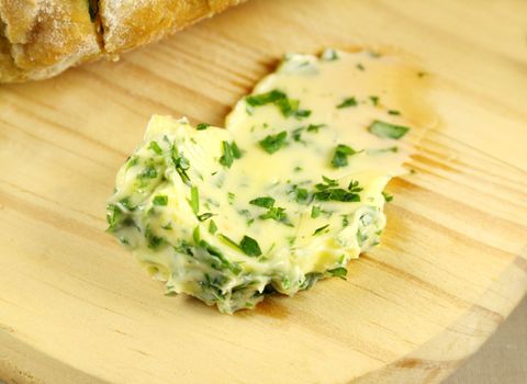 Delicious spread of freshly made garlic and herb butter ready to put on baked rolls.