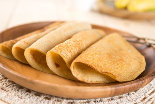 Asian style homemade banana pancakes or crepe on dining table.