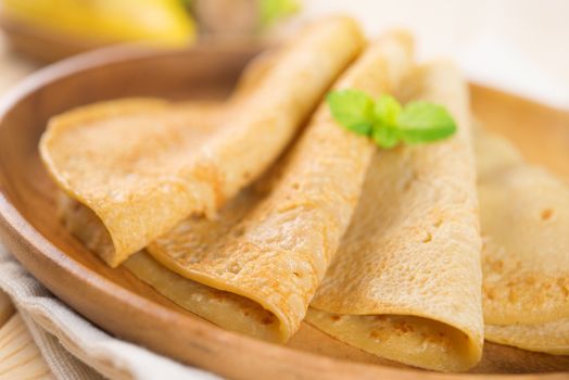 Close up Asian style breakfast homemade banana pancakes or crepe on dining table.