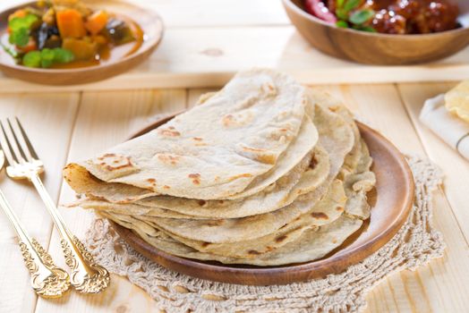 Chapatti roti or Flat bread, curry chicken and dhal. Indian food on dining table.