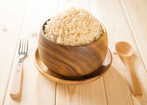 India cooked organic basmati brown rice in wooden bowl on dining table.