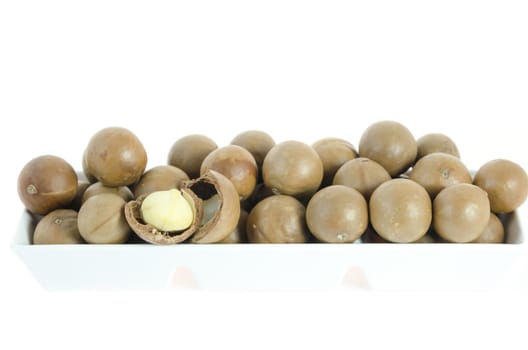 close up macadamia in  white bowl  on white background