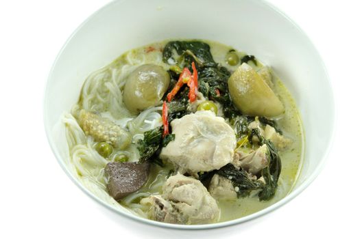 top view green chicken curry served with  rice vermicelli in white bowl over white background