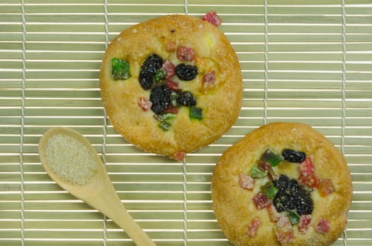 top view of  bread with raisin and  dried fruits , spoon of sugar on wooden background 