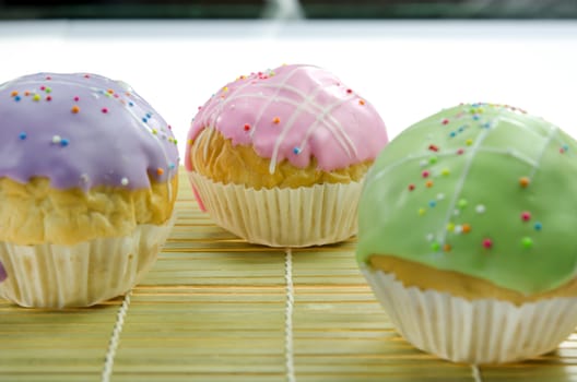 close up  cupcake with colorful sprinkles on wooden board