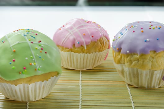 close up  sweet  cupcake with colorful sprinkles on wooden board , delicious dessert
