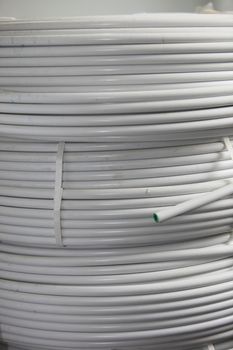 Close up view of three stacked rolls of electrical cable and conduit for use in a domestic electrical installation