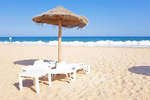 Thatched umbrella and beach chairs on the beach near Lagos Portugal