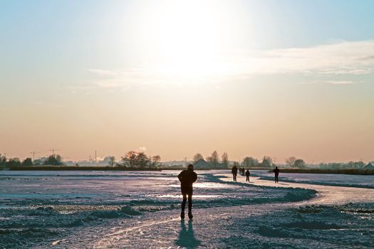 Ice skating in the countryside from the Netherlands at sunset
