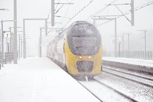 Train driving in snowstorm in winter in the Netherlands