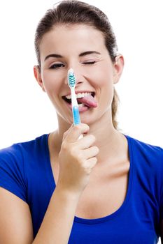Beautiful woman with funny face holding toothbrush, isolated over a white background