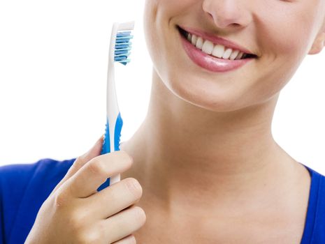 Beautiful woman with a great smile holding toothbrush, isolated over a white background