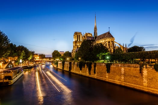 Notre Dame de Paris Cathedral and Boat Lights Trails on Seine River, Paris, France