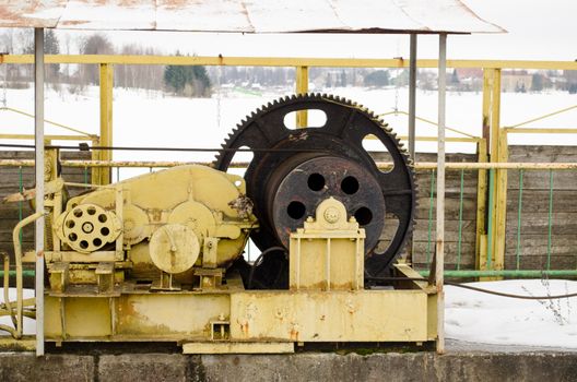 closeup mechanism screw with tense steel cable hold river dam gate