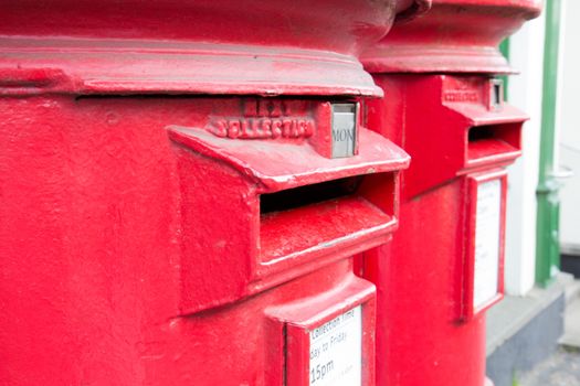 Closeup of two traditional British red mail boxes.