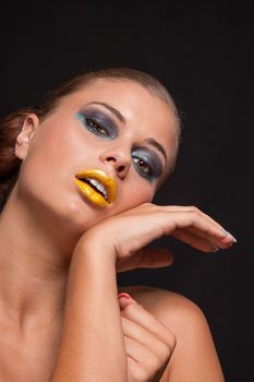 woman with extreme colorfull make up in blue and yellow on black background