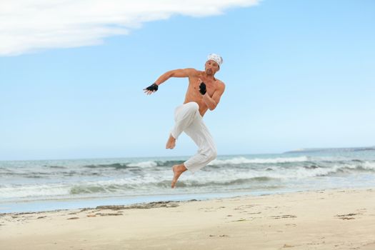 man is jumping sport karate martial arts fight kick jump beach summertime