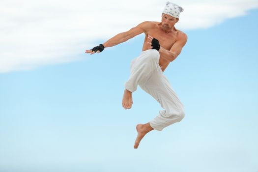 man is jumping sport karate martial arts fight kick jump beach summertime
