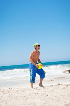 attractive young man playing volleyball on the beach summertime 