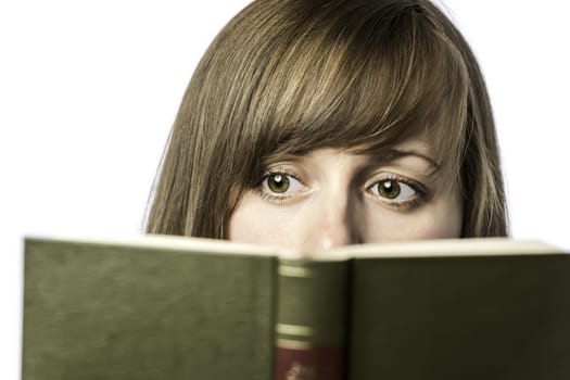 Young pretty female student reads a book to learn, isolated on white background