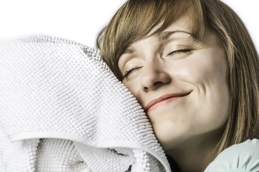 Young pretty girl cuddling with her eyes closed in a towel, isolated on white background