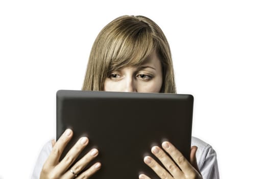 Young pretty woman looks on her tablet computer, isolated on white background