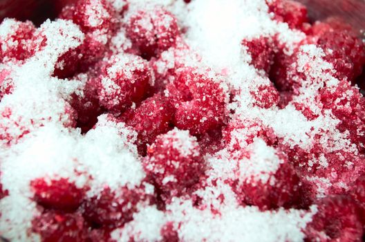 Ripe juicy raspberries liberally sprinkled with sugar