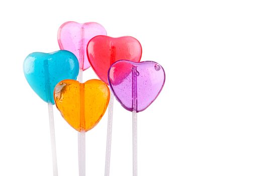 Five different colored heart lollipops on a white background.