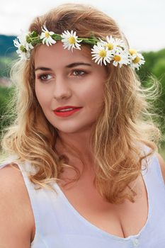 Portrait of a young blond woman with daisy wreath on head