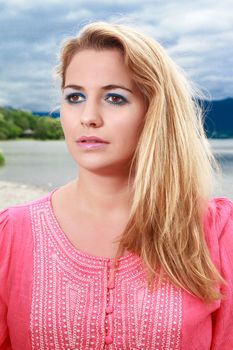 Portrait of a beautiful cute young woman with piercing eyes and long blond hair
