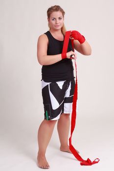 Young blond female boxer is bandaging your hands