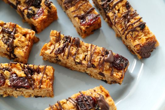 Fresh baked muesli bars with melted chocolate drizzled over the top.