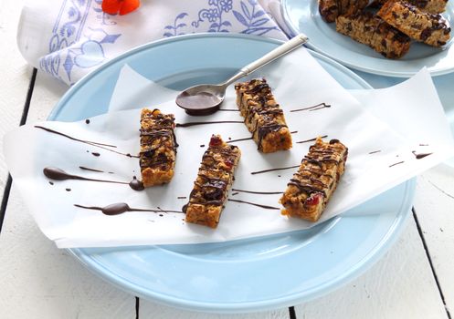 Fresh baked muesli bars with melted chocolate drizzled over the top.