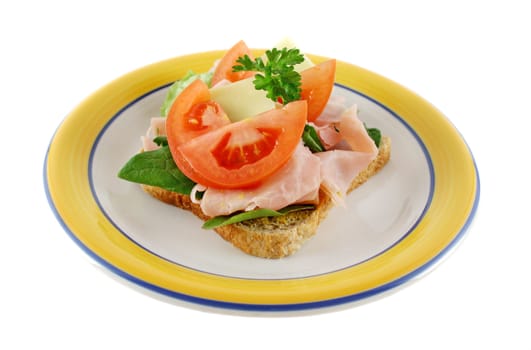 Ham, lettuce, tomato and cheese open sandwich on wholemeal bread.  