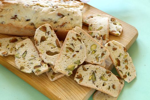 Fresh baked sweet pistachio bread sliced on a bread board ready to serve.