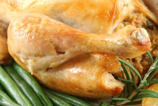 Roasted chicken drumstick with green beans and rosemary.