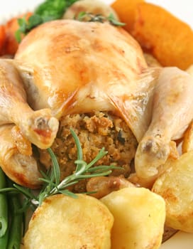 Whole roast chicken with potatoes pumpkin carrots and beans.