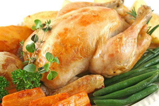 Whole roast chicken with potatoes pumpkin carrots and beans.