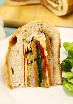 Slice of savory cob loaf filled with ham, salami, aubergine, cottage cheese and vegetables.