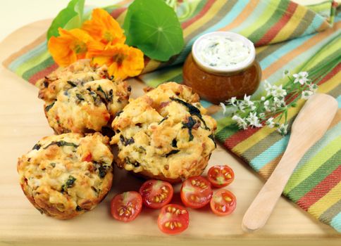 Fresh baked savory muffins with herb spread and cherry tomatoes.