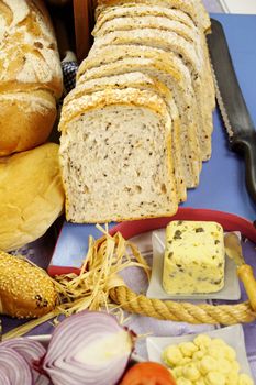 Sliced bread with selected rolls with herb butter ready to serve.