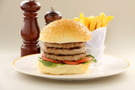 Triple decker hamburger with fries ready to serve.