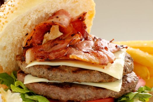 Double decker hamburger with bacon and cheese ready to serve.