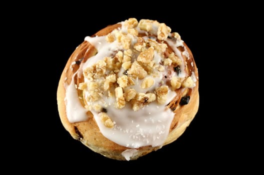 Delicious sweet iced bun with walnuts and coconut.